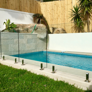 Frameless glass pool fence with polished chrome spigots